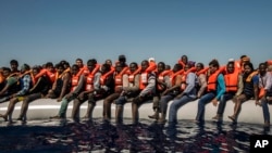 Des réfugiés et des migrants en provenance de l'Érythrée, du Mali, du Bangladesh et d'autres pays attendent, à bord d'un canot, d'être secourus dans la mer Méditerranée, à 27 kilomètres (17 miles) au nord de Sabratha, Libye, 19 juillet 2016. 