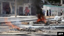 Kebakaran-kebakaran di jalan menyusul penembakan seorang sopir tuktuk dan penumpangnya, 13 April 2019, di Mogadishu.