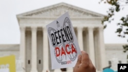 FILE - In this Nov. 12, 2019, photo, people rally outside the Supreme Court. The Trump administration must accept new applications for the DACA program that protects some young immigrants from deportation, a federal judge ruled Dec. 4, 2020.
