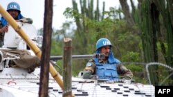 Des casques patrouillent à bord d'un véhicule blindé sur une route près de Tongo, à 45 km au nord de Goma, Nord-Kivu, 11 mars 2014..