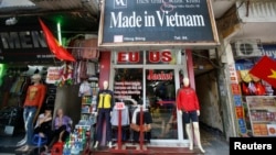 ARSIP - Para pedagang duduk di luar sebuah kios yang menjual pakaian di Hanoi pada foto yang diambil tanggal 3 Oktober 2014 (foto: Reuters/Kham)
