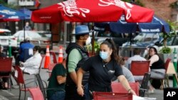 Konobarica smešta goste u bašti restorana na ulici zatvorenoj za saobraćaj u Somervilu u Masačusetsu 17. jula 2020.