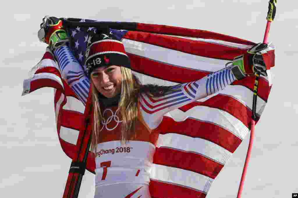 美国滑雪选手米凯拉·席弗琳在平昌冬奥会高山滑雪女子大回转比赛中获得冠军后展示美国国旗(2018年2月15日)。 比赛原定在星期三进行,但由于当地的强风警报而推迟一天。在两个回合的比赛中,美国的席弗琳以总成绩2分20秒02获得冠军。挪威名将莫温克尔获得银牌。意大利名将布里尼诺内在第一回合后曾排名第一,但在第二回合中发挥异常,只获得铜牌。