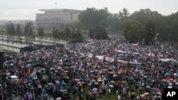 Polisi anti huru hara memblokir jalan untuk menghentikan demonstrasi pendukung oposisi Belarusia di dekat Istana Kemerdekaan (latar belakang), di Minsk, Belarus, Minggu, 6 September 2020. 
