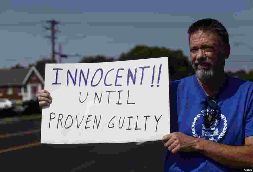 A demonstrator supporting Ferguson Police officer Darren Wilson holds up a sign during a rally in St. Louis, Missouri Aug. 23, 2014.