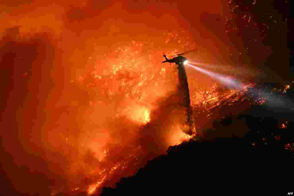 Helikopter za gašenje požara ispušta vodu na požar koji se širi u Mandevil kanjonu, 11. januara 2025.
