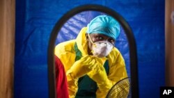 Seorang petugas kesehatan memakai alat pelindung sebelum memasuki pusat perawatan Ebola di Freetown, Sierra Leone.