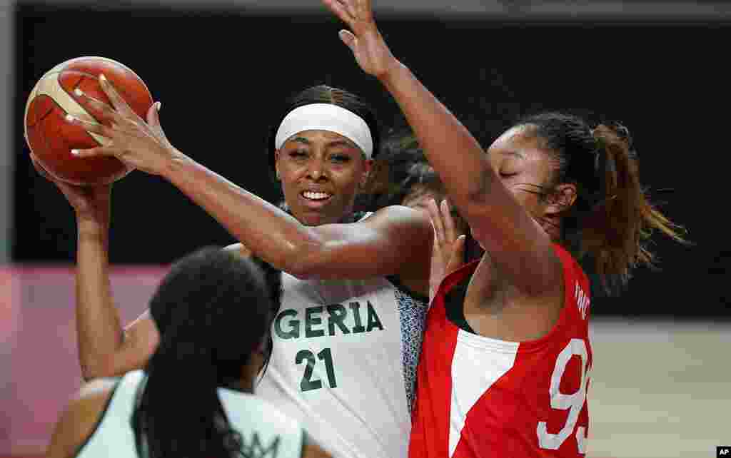 Nigeria's Atonye Nyingifa (21) passes around Japan's Monica Okoye (99), right, during women's basketball preliminary round game at the 2020 Summer Olympics, Monday, Aug. 2, 2021, in Saitama, Japan. (AP Photo/Charlie Neibergall)