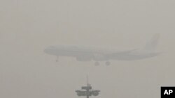Avion Er Čajna sprema se da sleti na međunarodni aerodrom u Pekingu kroz oblak smoga