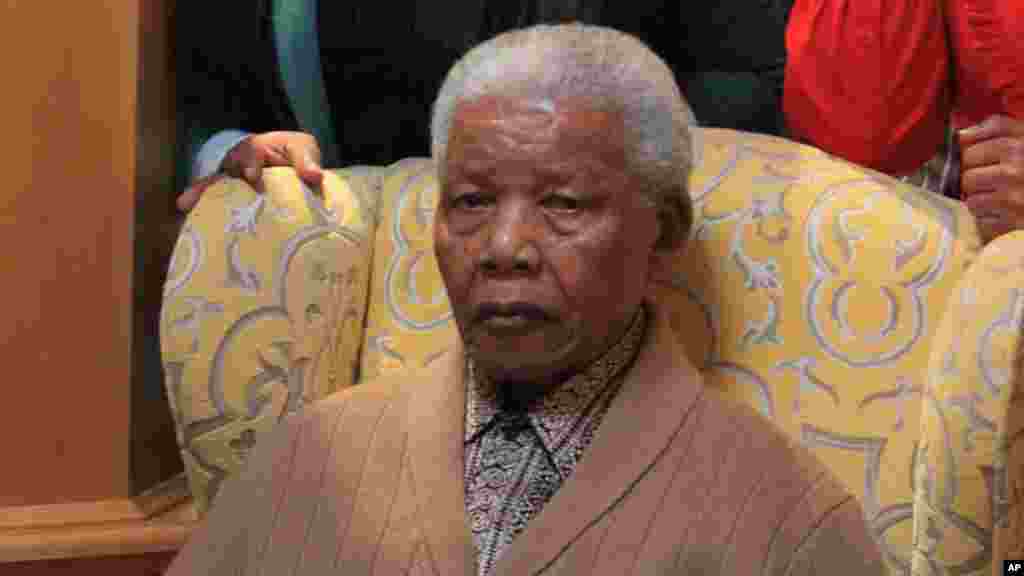 Mandela poses for a photograph after receiving a torch to celebrate the African National Congress' centenary in his home village, Qunu, in rural eastern South Africa, May 30, 2012.