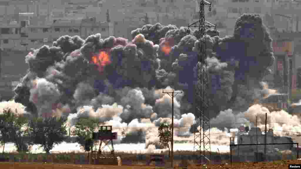 Smoke and flames rise from an Islamic State fighters' position in the town of Kobani during airstrikes by the US led coalition seen from the outskirts of Suruc, near the Turkey-Syria border, Oct. 28, 2014.