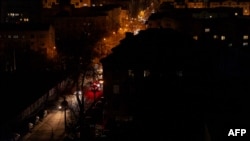 Автомобілі їдуть неосвітленою вулицею під час часткового відключення світла в Києві, 28 листопада 2024 року, після ударів Росії по українській енергетичній інфраструктурі на тлі російського вторгнення в Україну. Tetiana DZHAFAROVA/AFP