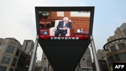 TV program o poseti bivšeg američkog državnog sekretara Henrija Kisindžera Pekingu emituje se na džinovskom ekranu ispred jednog tržnog centra u Pekingu, 20. jula 2023. (Foto: AFP/Greg Baker)