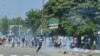 Des partisans de l'ancien président ivoirien Laurent Gbagbo affrontent la police anti-émeute à Abidjan, le 17 juin 2021, avant son arrivée dans le pays.