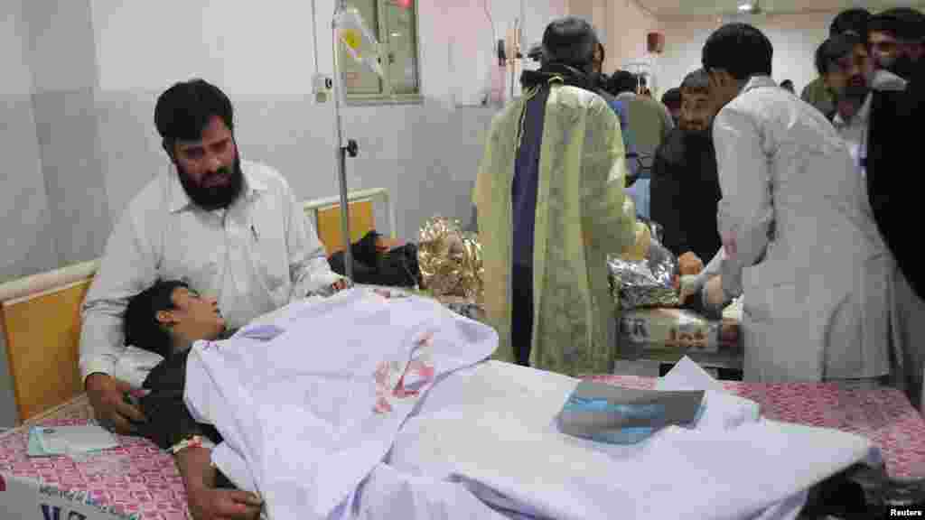 A man comforts his son, who was injured during an attack by Taliban gunmen on the Army Public School, at Lady Reading Hospital in Peshawar, Pakistan, Dec. 16, 2014.