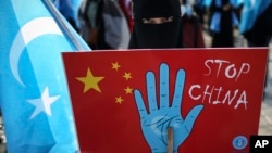 在土耳其首都伊斯坦堡的維吾爾人手舉抗議中國的標語牌參加示威集會。（2021年3月25日）