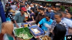 Office workers shop for "iftar," the meal to break their fast on the first day of the holy fasting month of Ramadan, at the main business district in Jakarta, Indonesia, June 18, 2015.