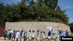 Believers gather to pray outside the church of St. Rock for the release of clergy members, including two French citizens, who were kidnapped, in Port-au-Prince, Haiti, April 12, 2021.