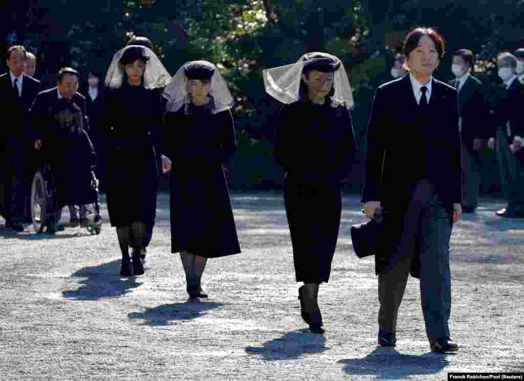 Japan's Crown Prince Akishino and Crown Princess Kiko walk, followed by Princess Aiko and Princess Kako, to attend a funeral service for Princess Mikasa at Toshimagaoka cemetery in Tokyo.