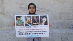 Nursiman Abdureshid sostiene fotografías de sus padres y dos hermanos, en Estambul en mayo.