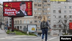 塞爾維亞一名女子走過貝爾格萊德街頭樹立的感謝中國領導人習近平的廣告牌旁。 （2020年4月1日）