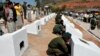 In this photo released by the Myanmar Defense Ministry, soldiers place urns containing ashes of soldiers fallen during recent fighting against ethnic Kokang rebels at a military funeral in Lashio, Myanmar, Feb. 23, 2015.