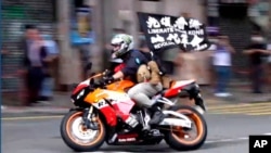 2020年7月1日唐英杰驾车时展示“光复香港，时代革命”的旗帜。
