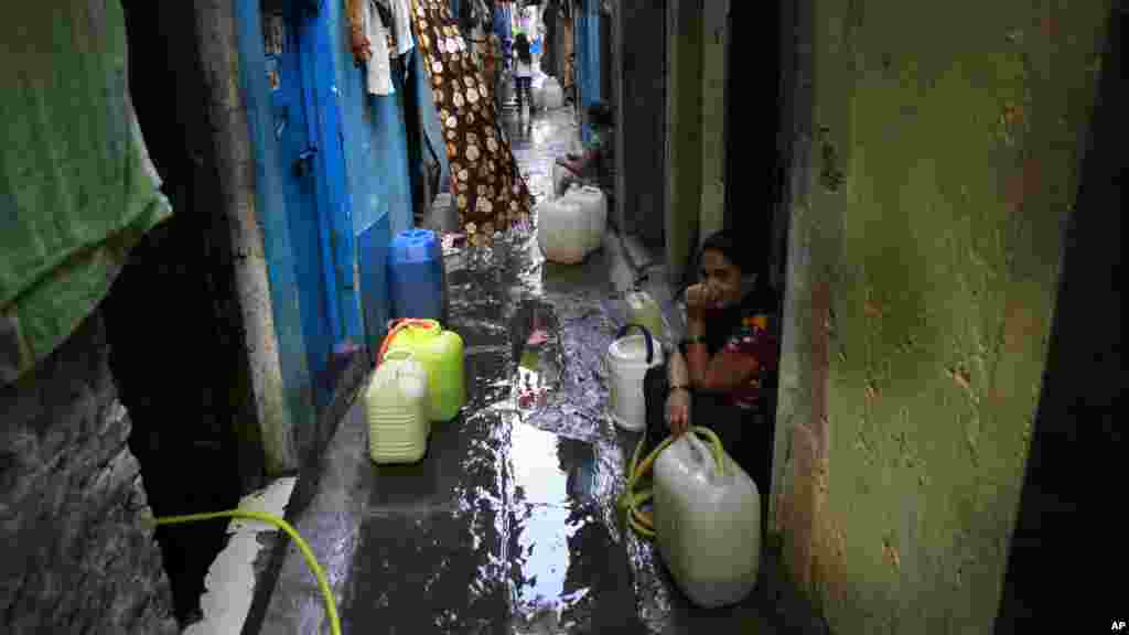 Des femmes récupèrent de l'eau d'un robinet dans un bidonville à Mumbai, en Inde, le 22 mars 2017.