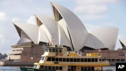 Sebuah kapal feri berlayar melewati Opera House di Sydney, Australia, Selasa, 6 April 2021. (AP Photo/Rick Rycroft)