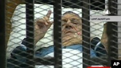 Former Egyptian President Hosni Mubarak gestures in the courtroom during his trial at the police academy in Cairo, August 15, 2011