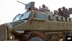 FILE - Soldiers from the Uganda People's Defense Force (UPDF) are seen driving in an armored vehicle through the streets of Bor, Jonglei State, South Sudan, Jan. 19, 2014.