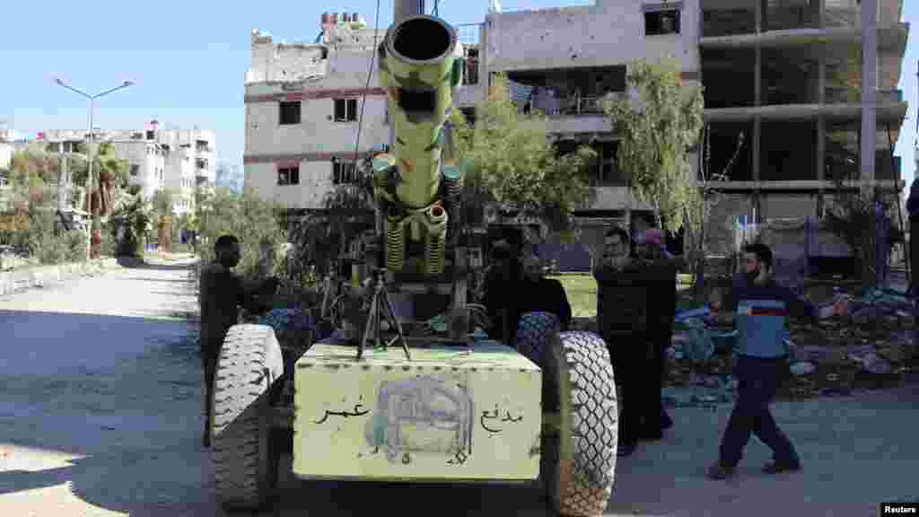 Free Syrian Army fighters prepare to fire an artillery cannon towards forces loyal to Syria's President Bashar al-Assad in the eastern Damascus suburb of Ghouta, March 23, 2014.