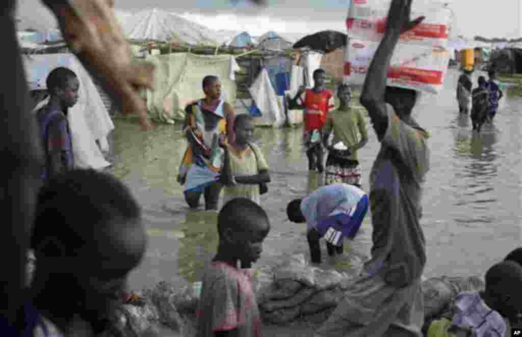 Des déplacés Sud Soudanais marchent dans un marécage d’une eau boueuse près de la Mission Onusienne au Sud Soudan (UNMISS) au village de Bentiu, au Sud Soudan.