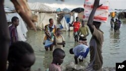ARCHIVES - Des déplacé Sud-Soudanais traversent les eaux d'innondation pour vendre leurs produits agricoles près 'une base de la mission des Nations unies à Bentiu, Soudan du Sud, le 22 septenbre 2014. 