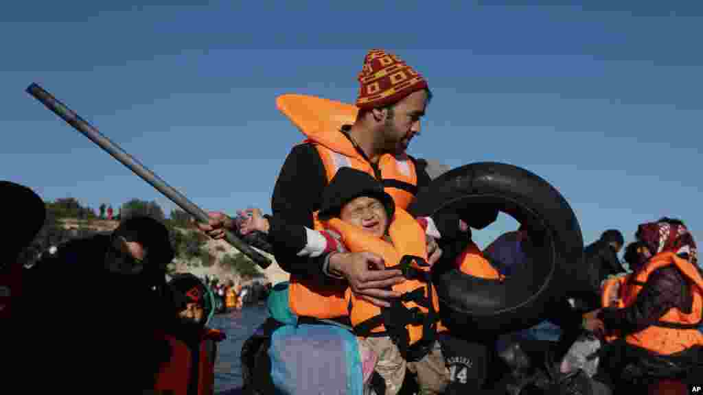Un enfant porté par un adulte pleure lors d’une traversée des migrants en canot à l'île grecque de Chios, en Turquie, 4 novembre 2015.
