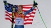 Men's giant slalom gold medalist Ted Ligety of the United States poses for photographers on the podium at the Sochi 2014 Winter Olympics, in Krasnaya Polyana, Russia, Feb. 19, 2014.