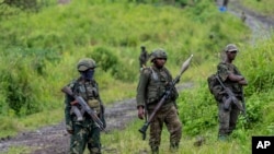 FILE - M23 rebels stand with theirs weapons in Kibumba, in the eastern of Democratic Republic of Congo, Dec. 23, 2022..(AP Photo/Moses Sawasawa)