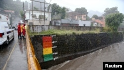 Rescatistas observan el nivel de un río mientras la tormenta tropical Julia golpea con viento y lluvia en San Salvador, el 10 de octubre de 2022. REUTERS/José Cabezas