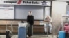 Passengers wait for confirmation of flights outside the Swissport Ticket Sales counter as several airlines stopped flying out of South Africa, amidst the spread of the new Omicron variant at O.R. Tambo International Airport in Johannesburg, South Africa, 
