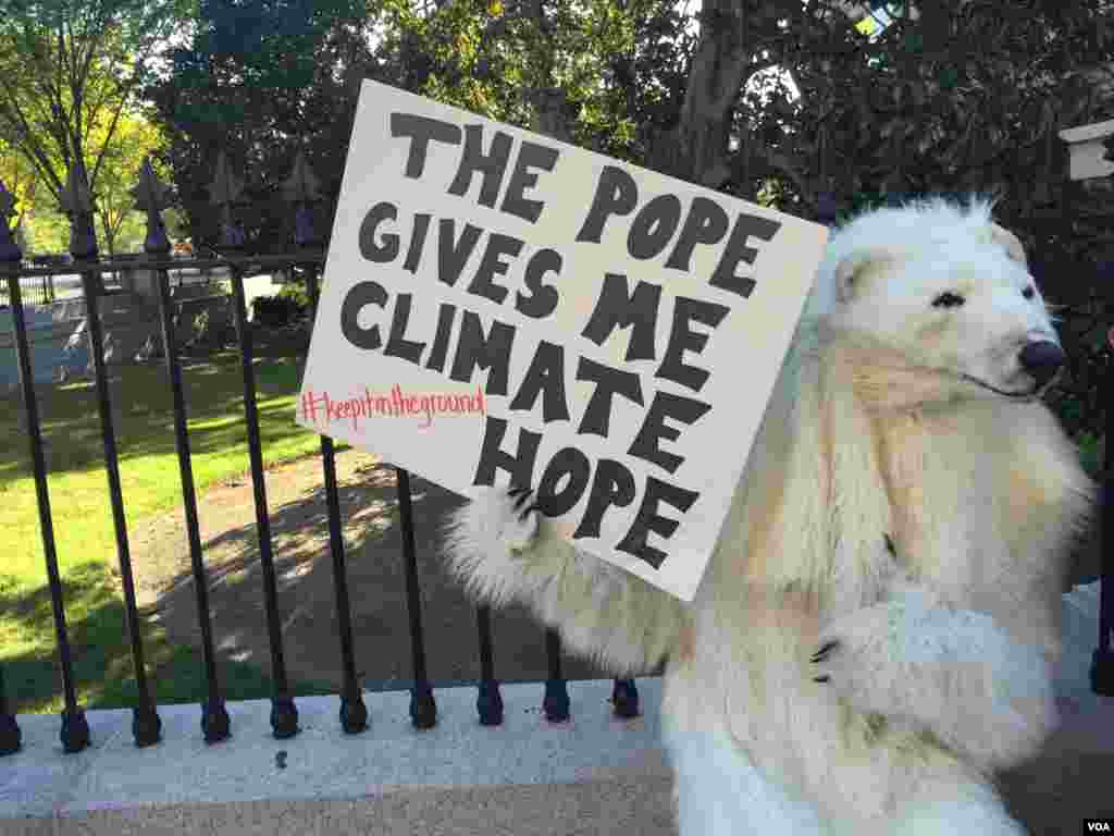 Une personne en costume d'ours polaire montre son soutien à la position du pape François sur le changement climatique, en face de la Maison Blanche.