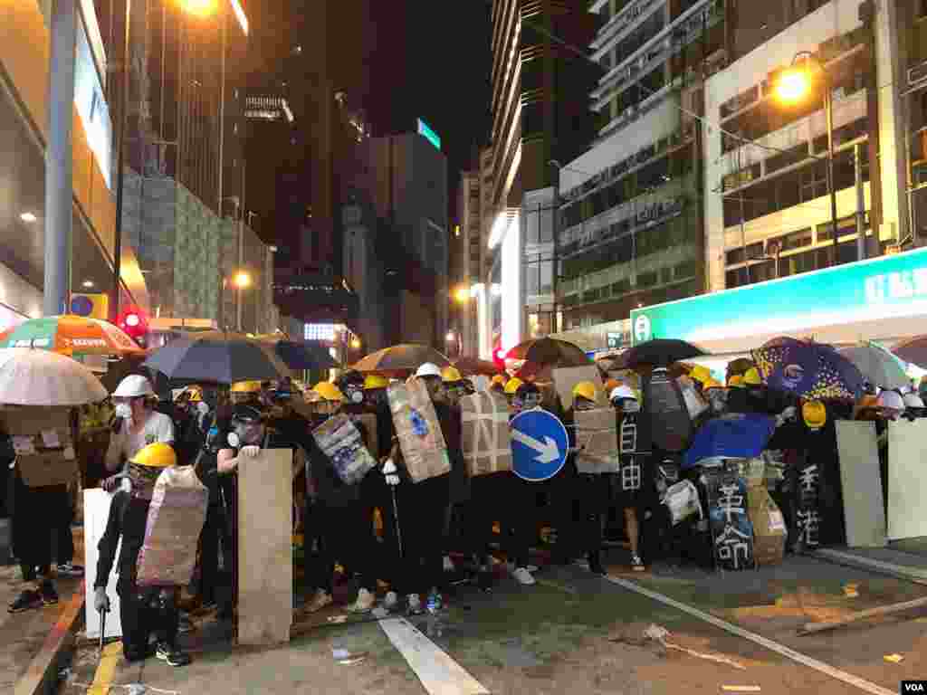 2019年7月28日晚,中環遮打花園反送中集會演變成群眾自發遊行,一批示威者在上環集結築起防線與警方防暴警察對峙。