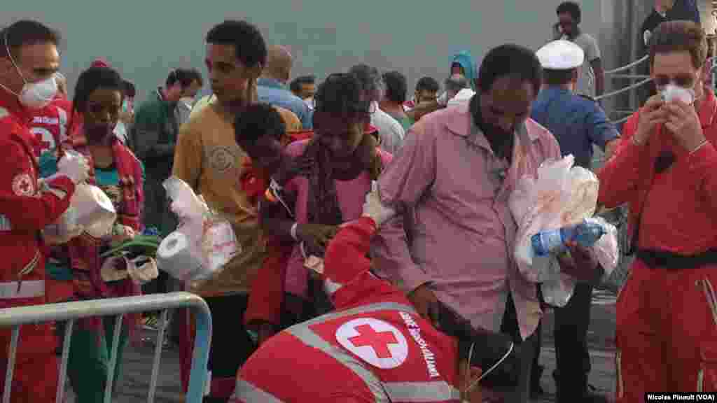 Après avoir reçu quelques produits de première nécessité, les migrants passent un examen médical préliminaire au poste de la Croix Rouge italienne à Catane, Sicile, 6 octobre 2015 (Nicolas Pinault/VOA).