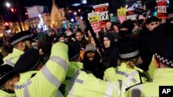 People scuffle with police during an anti-Boris Johnson demonstration, at Trafalgar Square in central London, Dec. 13, 2019. 