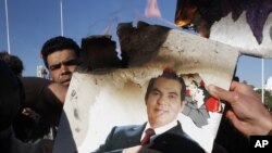 Des protestataires brûlent une photo de l'ancien président tunisien Zine el Abidine Ben Ali lors d'une manifestation à Tunis, le 24 janvier 2011.