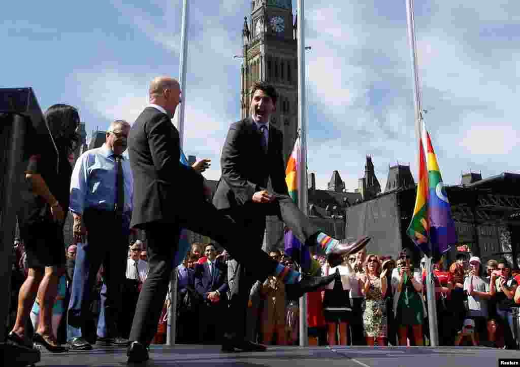 Canada's Prime Minister Justin Trudeau (R) compares socks with Liberal MP Randy Boissonnault during a pride flag raising ceremony on Parliament Hill in Ottawa, Ontario, June 14, 2017.