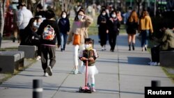 A girl wearing a protective face mask to prevent contracting the coronavirus disease (COVID-19) rides a toy kick scooter at a park in Seoul, South Korea, April 3, 2020. REUTERS/Heo Ran