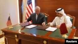 Le ministre des Affaires étrangères du Qatar, Cheikh Mohammed bin Abdulrahman al-Thani, à droite, et le Secrétaire d'État américain Rex Tillerson, signent un mémorandum d'accord à Doha, au Qatar, le 11 juillet 2017.