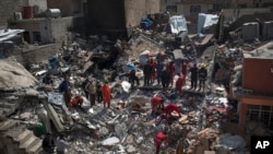 Civil protection rescue team work on the debris of a destroyed house to recover the bodies of people killed on the western side of Mosul, Iraq, March 24, 2017.