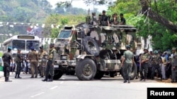 Sri Lanka's army soldiers stand guard a road after a clash between two communities in Digana, central district of Kandy, Sri Lanka, March 6, 2018.