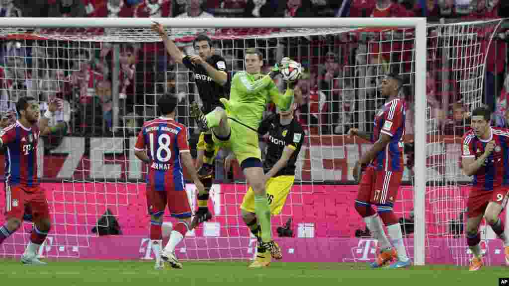 Le gardien de but du Bayern Manuel Neuer sauve une balle lors du match de football de première division allemande de la Bundesliga entre le FC Bayern et le Borussia Dortmund dans l'Allianz Arena à Munich, Allemagne, le samedi 1 novembre 2014.